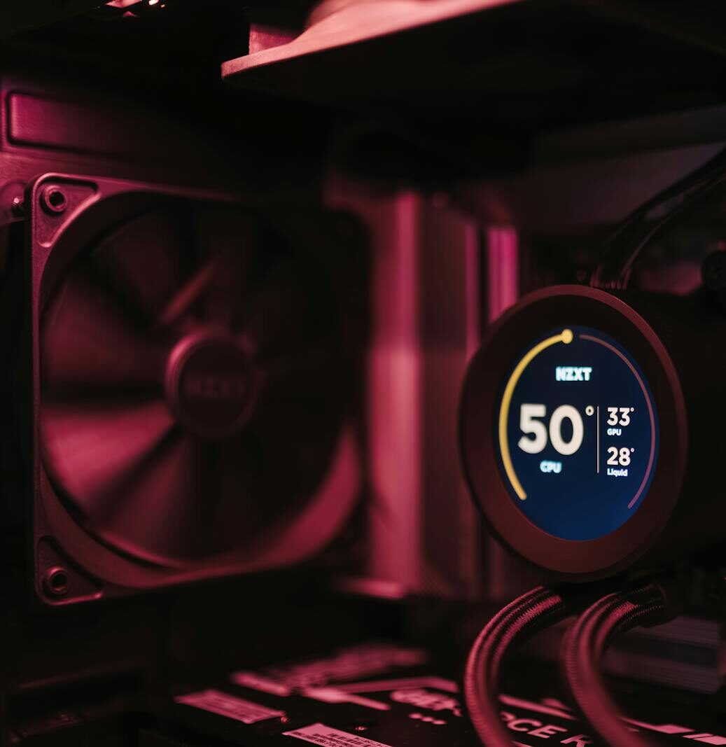 Close-up of a PC cooling system and motherboard, highlighting digital temperature display.